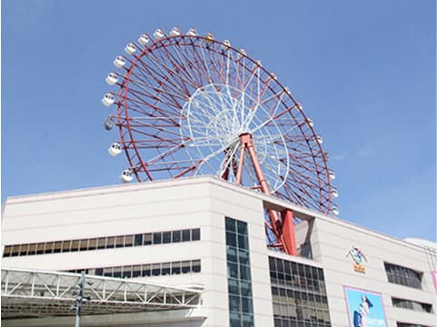 多くの窓がある現代的な白い建物の屋上に設置された大きな観覧車。
